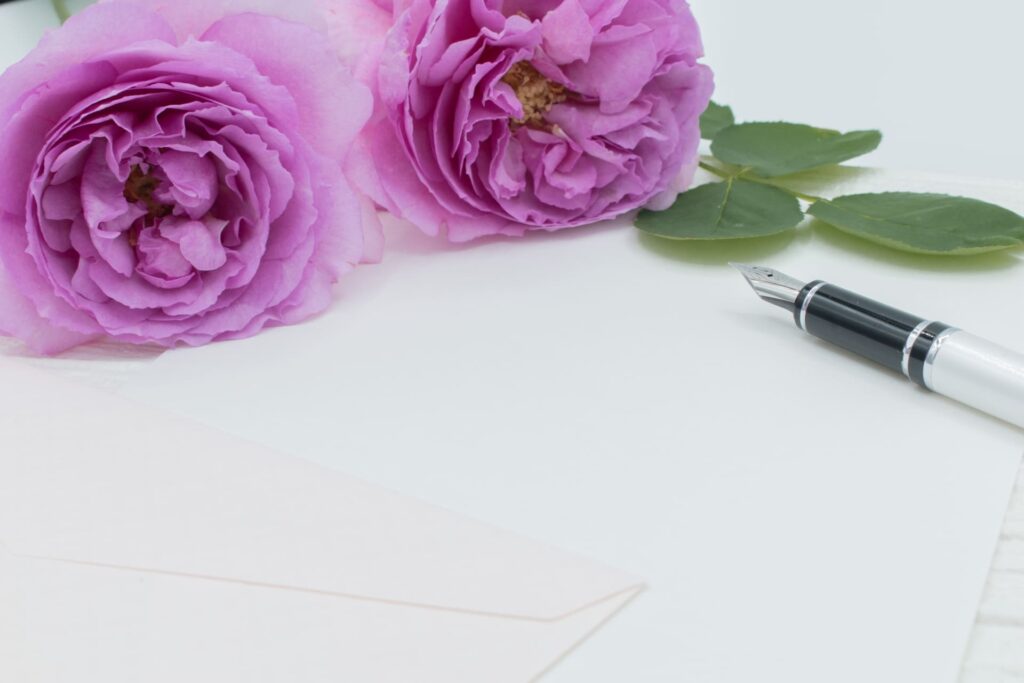 紫色の花と万年筆と便箋と封筒