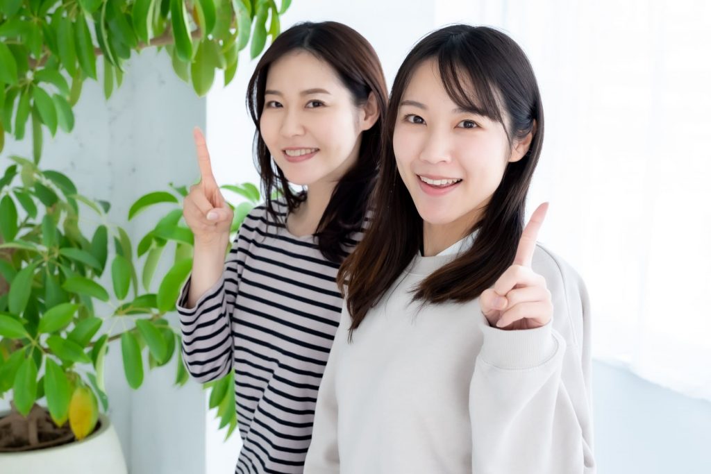 人差し指を立てる2人の日本人女性