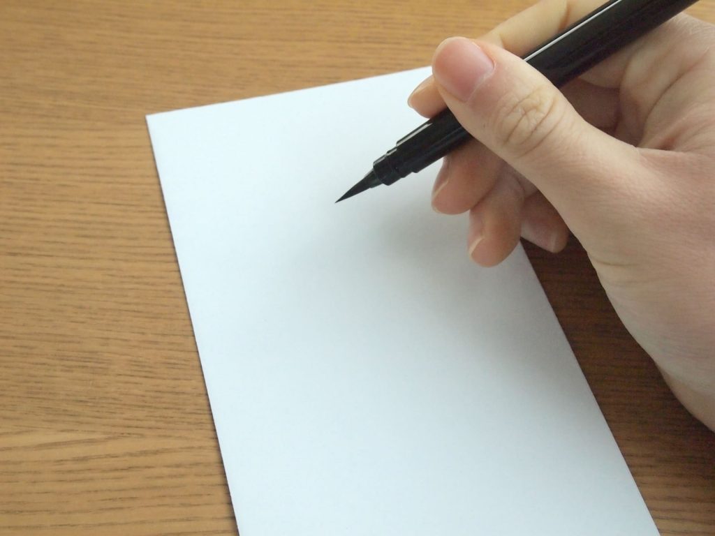 白い封筒と筆ペン