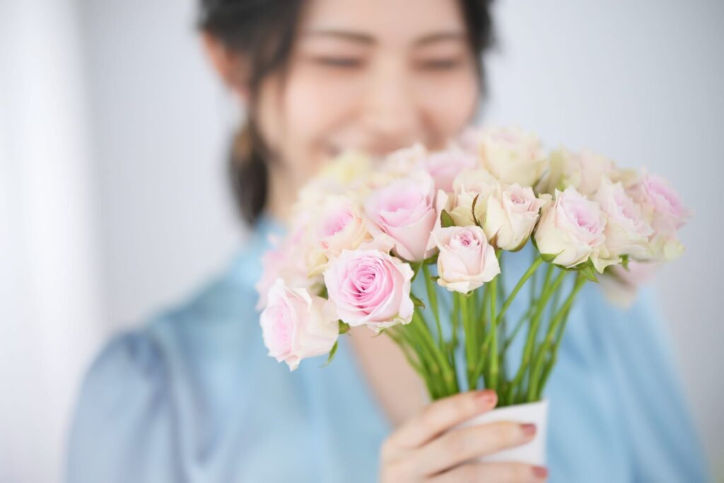 花束を持ち微笑む女性