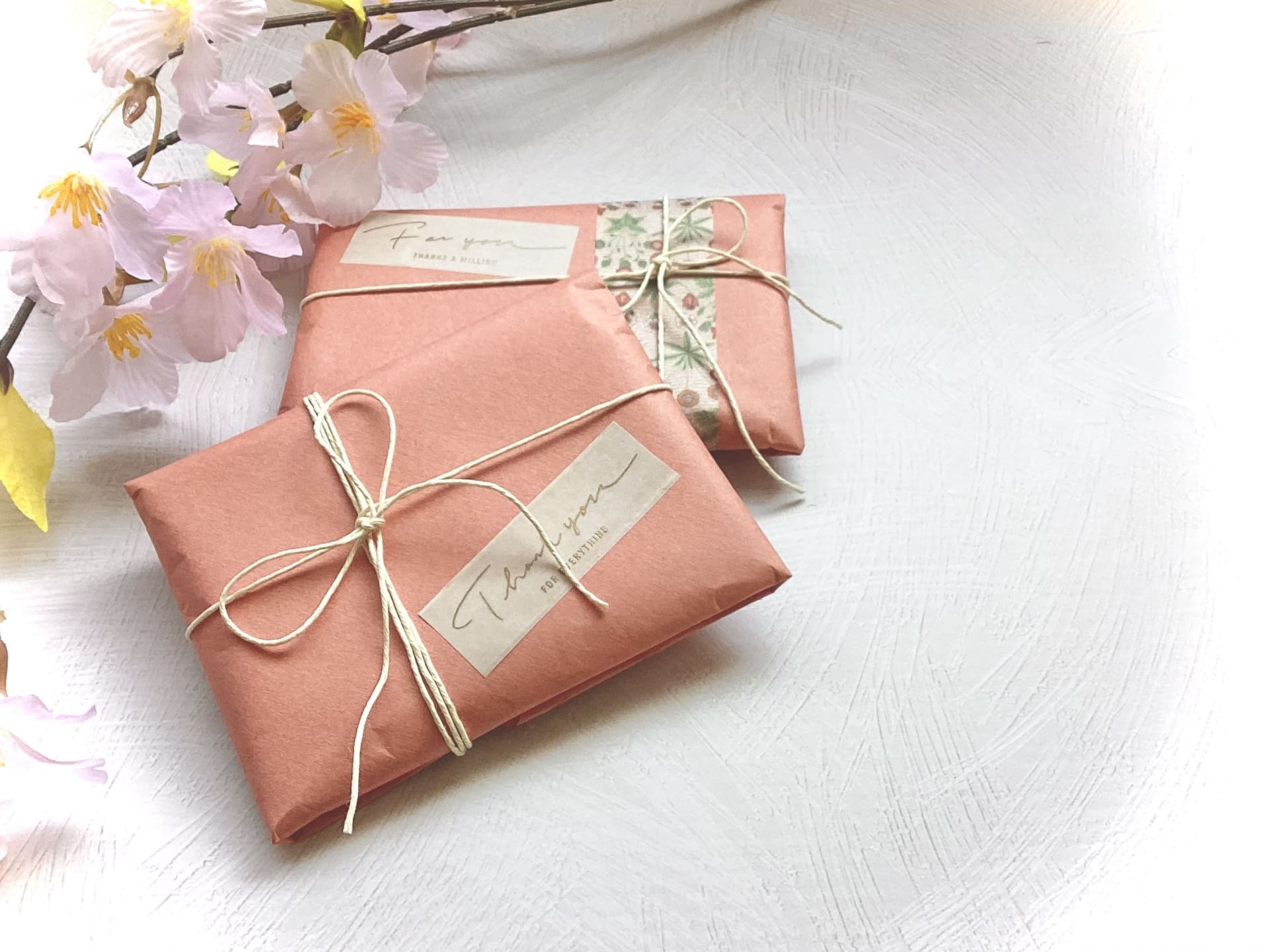 ピンクの包みの小さなプレゼントと桜