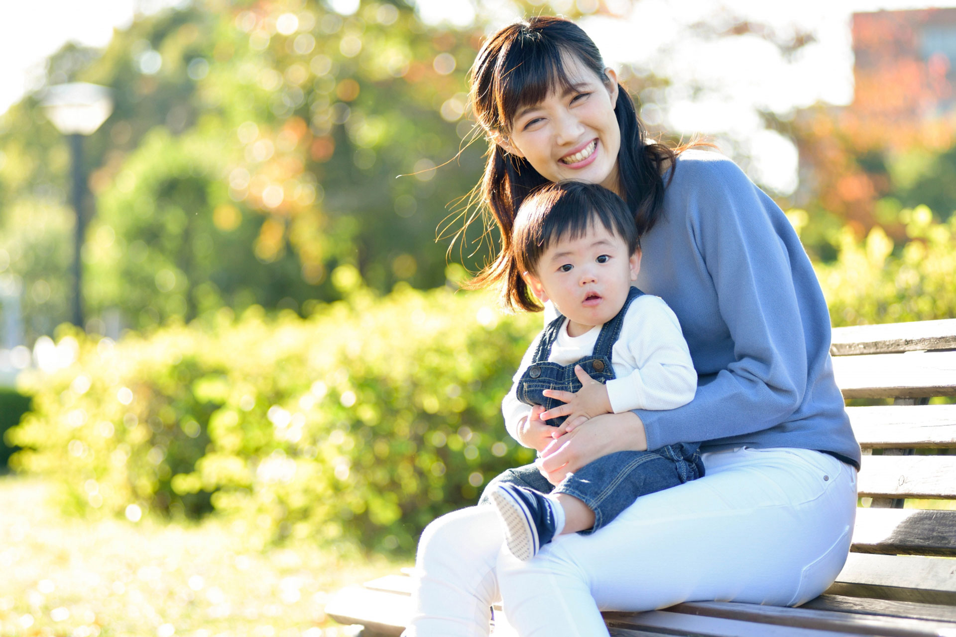 公園にいる笑顔の赤ちゃんと母